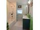 Bright bathroom featuring textured shower tile, sleek vanity, and decorative oval mirror at 1044 Towhee Ln, McClellanville, SC 29458