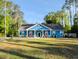 Charming blue single-story home with a welcoming front porch and well-maintained yard at 1044 Towhee Ln, McClellanville, SC 29458