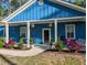 Inviting front porch with charming decorations and colorful flowers enhancing the home's curb appeal at 1044 Towhee Ln, McClellanville, SC 29458