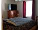 Bedroom with cozy bedding, dresser and flat screen TV near a bright window at 107 Kelly St, Walterboro, SC 29488