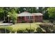 Charming red-brick home with well-maintained lawn and mature trees behind a chain link fence at 107 Kelly St, Walterboro, SC 29488
