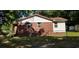 Side view of a red brick home featuring a metal roof and a partially fenced yard at 107 Kelly St, Walterboro, SC 29488