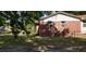 Side view of red brick home featuring a metal roof and a partially fenced yard and mature trees at 107 Kelly St, Walterboro, SC 29488
