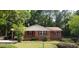 Charming red-brick home with well-maintained lawn and mature trees behind a chain link fence at 107 Kelly St, Walterboro, SC 29488