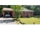 A well-manicured lawn complements this red brick home with red shutters and a covered carport at 107 Kelly St, Walterboro, SC 29488