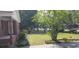 Well-maintained front yard with lush green grass and various trees and bushes at 107 Kelly St, Walterboro, SC 29488