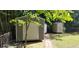 Backyard with three storage sheds, greenery, and a brick-lined walkway at 107 Kelly St, Walterboro, SC 29488