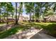 Large backyard featuring tall trees, a wooden fence, and a concrete patio, ideal for outdoor activities at 107 Spalding Cir, Goose Creek, SC 29445