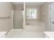 Bright bathroom featuring a soaking tub, separate shower, and white tile flooring at 107 Spalding Cir, Goose Creek, SC 29445