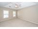 Spacious bedroom with two windows, neutral carpet, and a tray ceiling with a ceiling fan at 107 Spalding Cir, Goose Creek, SC 29445