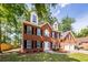 Charming two-story brick home featuring classic black shutters, dormer windows, and an attached two-car garage at 107 Spalding Cir, Goose Creek, SC 29445