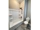 Bathroom featuring a bathtub with shower head, toilet, and decorative patterned flooring at 107 Tracy St, Walterboro, SC 29488