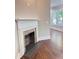 Living room fireplace with white mantle and brick interior next to hardwood floors and natural light at 107 Tracy St, Walterboro, SC 29488