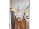 Kitchen view featuring an island, stainless appliances, custom cabinets, marble countertops, and wood floors at 107 Tracy St, Walterboro, SC 29488