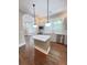 Kitchen with an island, stainless appliances, a window over the sink, custom cabinets, marble countertops, and wood floors at 107 Tracy St, Walterboro, SC 29488