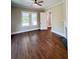 Spacious living room featuring hardwood floors, ceiling fan, open door and bright windows at 107 Tracy St, Walterboro, SC 29488