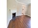 Charming living room featuring hardwood floors, brick fireplace and open doorway to bathroom at 107 Tracy St, Walterboro, SC 29488