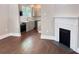 View of hardwood floors, modern fireplace and open archway into kitchen at 107 Tracy St, Walterboro, SC 29488