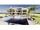 Expansive backyard featuring a stunning pool area with lounge chairs, palm trees, and stylish outdoor furniture at 11 Tabby Ln, Isle of Palms, SC 29451