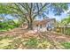 Backyard view showcases the house and trees and the foliage surrounding this cozy single-Gathering home at 1143 Winborn Dr, Charleston, SC 29412