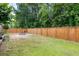 A fully fenced backyard with well maintained grass and a stone firepit at 118 Wando Reach Rd, Wando, SC 29492