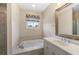 Bathroom with tub, window with decorative curtain, vanity with sink, and mirror at 118 Wando Reach Rd, Wando, SC 29492