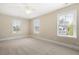 Bright bedroom with neutral walls, carpet, ceiling fan, and three large windows providing ample natural light at 118 Wando Reach Rd, Wando, SC 29492