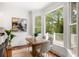 Elegant dining area with bright natural light, modern decor, and views of lush greenery through large windows at 118 Wando Reach Rd, Wando, SC 29492