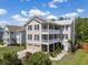 Beautiful three-story home with double porches, two-car garage, and manicured landscaping at 118 Wando Reach Rd, Wando, SC 29492