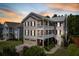 Striking three-story home with double porches, a two-car garage and sunset sky at 118 Wando Reach Rd, Wando, SC 29492