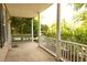 Covered porch with white columns and railings, offering a relaxing outdoor space surrounded by lush greenery at 120 Full Moon Ct, Ladson, SC 29456
