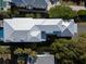 Overhead view of a luxury home featuring a sleek roof, pool with lounge chairs, and surrounded by lush landscaping and trees at 124 Charleston Blvd, Isle of Palms, SC 29451