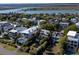 An aerial view of a neighborhood with houses and trees near a large body of water on a clear day at 124 Charleston Blvd, Isle of Palms, SC 29451