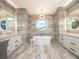 Luxurious bathroom with double vanities, a freestanding tub, and a unique round window at 124 Charleston Blvd, Isle of Palms, SC 29451