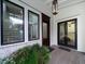Inviting front entry with a wood door, black framed windows, and lush greenery at 124 Charleston Blvd, Isle of Palms, SC 29451