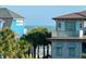 Beach homes with a view of the ocean between the buildings and palm trees at 124 Charleston Blvd, Isle of Palms, SC 29451