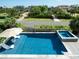 Relaxing pool and hot tub area with lounge chairs, umbrella, and lush green landscaping at 124 Charleston Blvd, Isle of Palms, SC 29451