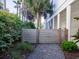 Side yard area featuring a wooden fence, gravel path, and lush green bushes at 124 Charleston Blvd, Isle of Palms, SC 29451