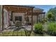 Backyard stone patio features an outdoor dining area with wooden pergola for shade at 124 Corral Cir, Summerville, SC 29485
