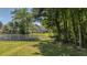Beautiful backyard with a white fence separating the yard from a wooded area creating a tranquil scene at 124 Corral Cir, Summerville, SC 29485