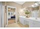 Bright bathroom featuring double vanity, linen closet, framed mirrors, and views into the main bedroom at 124 Corral Cir, Summerville, SC 29485