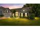Charming single-Gathering home featuring a manicured lawn and lush landscaping at dusk at 124 Corral Cir, Summerville, SC 29485