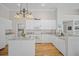 Bright, all-white kitchen with an island, stainless steel appliances, and granite countertops at 124 Corral Cir, Summerville, SC 29485