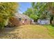 Backyard with brick house and lush greenery, with patio and detached garage in view at 13 Charlestowne Rd Rd, Charleston, SC 29407