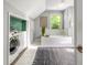 Bathroom with a bathtub, shower, laundry area and window with natural light at 13 Charlestowne Rd Rd, Charleston, SC 29407