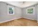 Bright bedroom with hardwood floors, two windows, and neutral walls at 13 Charlestowne Rd Rd, Charleston, SC 29407
