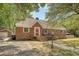 Charming brick home with a red front door, walkway, and lush green trees on a sunny day at 13 Charlestowne Rd Rd, Charleston, SC 29407