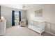 Bedroom with white ceiling fan, crib, glider, dark curtains and a map on the wall at 131 Beargrass Ln, Summerville, SC 29486