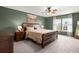 Green bedroom with a ceiling fan, painting and a bed with wood frame and nightstands with lamps at 131 Beargrass Ln, Summerville, SC 29486