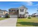 Beautiful two-story home with a brick and shingle facade and a well-manicured lawn under a clear blue sky at 131 Beargrass Ln, Summerville, SC 29486